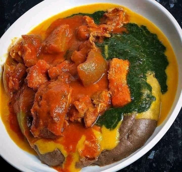 Gbegiri bean soup served with amala, ewedu and pepper stew